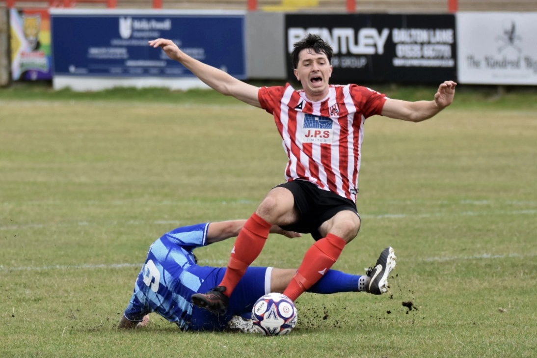 Guisborough defender James Frazer winces as he is hacked down by an Eccleshill opponent.